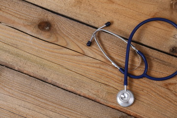 Closeup of a medical stethoscope, isolated on wooden background