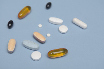 Prescription drugs isolated on a blue background, assorted tablets