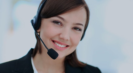 Happy young woman working at callcenter, using headset