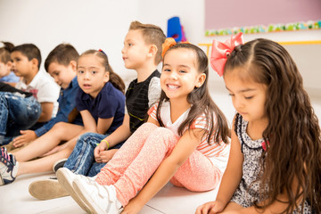 Preschool kids sitting on the classroom floor