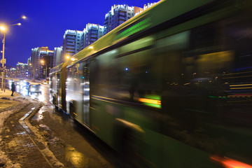Obraz premium The motion of a blurred bus on the avenue at dusk in the winter
