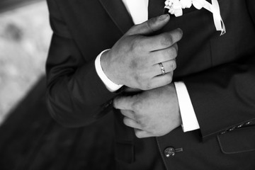 the groom adjusts his jacket at the wedding