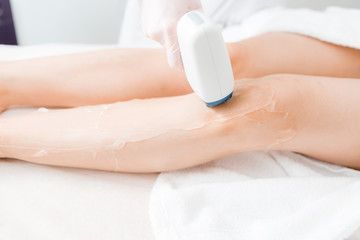 Laser epilation and cosmetology. Hair removal on ladies legs. at cosmetic beauty spa clinic. Cosmetology procedure from a therapist