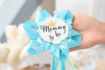 Woman holding award ribbon with text MOMMY TO BE on blurred background