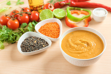 Composition with bowl of homemade lentils creme soup on table