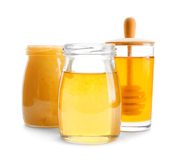 Jars with aromatic honey on white background