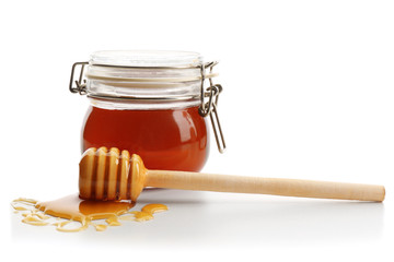 Jar of honey with dipper, isolated on white
