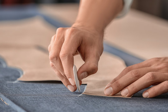 Young tailor working with sewing pattern, closeup
