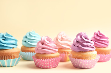 Delicious cupcakes on color background