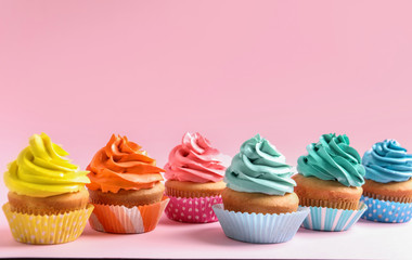 Delicious cupcakes on color background