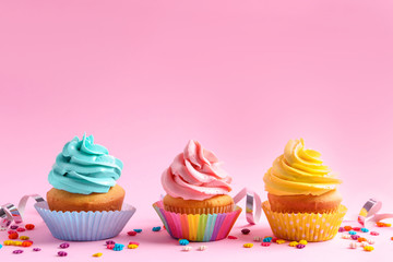 Delicious cupcakes on color background