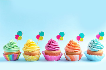 Delicious cupcakes on color background