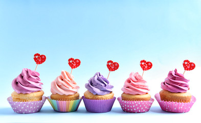 Delicious cupcakes on color background