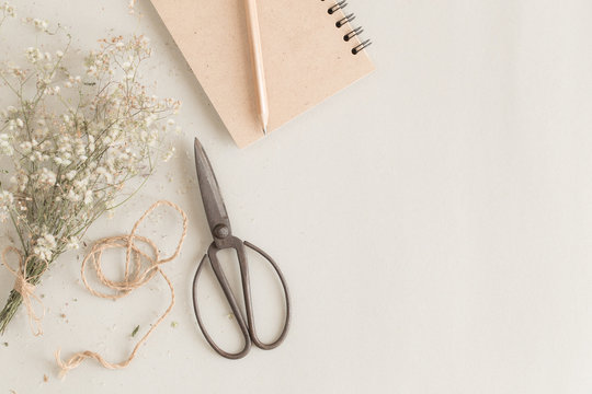 flat lay image with old scissors and notebook on paper background