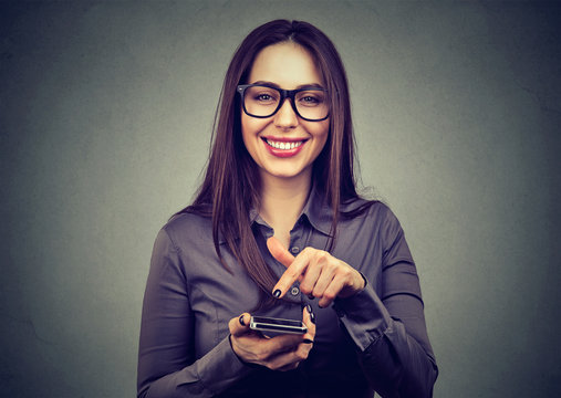 Content woman pointing at smartphone