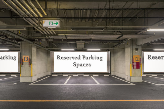 Parking garage underground interior with reserved parking apaces sign board