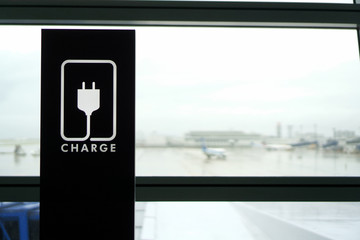 Obraz premium Rest area with CHARGE sign with Airport view though window