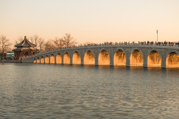 Fototapeta na wymiar The dusk in Summer Palace, a few days around the winter solstice, the height of the sun is the lowest at the dusk, the sun light can be filled with every hole of the seventeen hole bridge.
