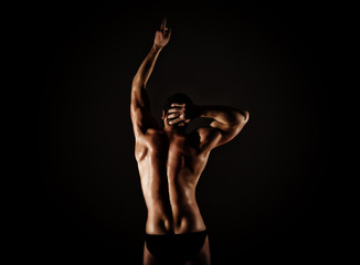 Fototapeta na wymiar Strong muscular man torso poses on black background