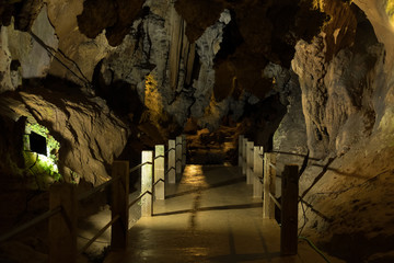 footbridge in stone cave. bridge in cavern with stalactite.