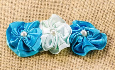 Rough texture of burlap, decorated with beautiful flowers from ribbons