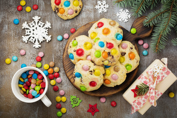 Children's cookies with colorful chocolate sweets in sugar glaze on brown concrete or stone background. Christmas card. Selective focus. Top view. Place for text.