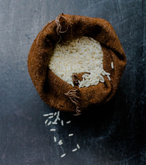 Thailand Rice on wooden table, rice in sackcloth and rice paddy on black wood,rice in sack,white rice in burlap sack with rice grain on the black wood