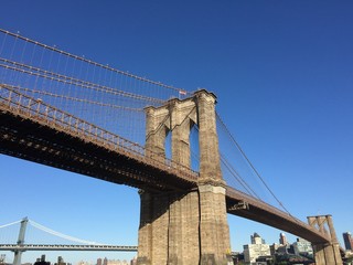 Obraz premium Brooklyn bridge and Manhattan bridge over river and buildings in Brooklyn, New York