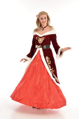 full length portrait of pretty blonde lady wearing red and white christmas inspired costume gown, standing pose on white background.