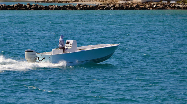 Open sport fishing boat powered by a single outboard engine cruising through Government Cut off Miami Beach,Florida