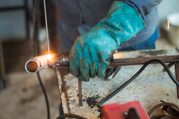 A man welds a metal with a welding machine
