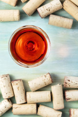 Wine glass and corks on teal background with copy space