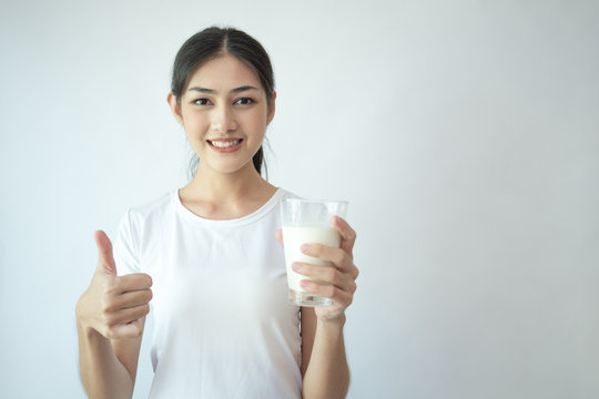 Young Asian Woman holding milk with smile on white background.