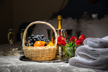 Champagne, fruits and flowers. Romantic room arrangement for a date
