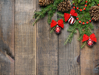 Christmas decorations and fir branches on wooden board background with copy space.