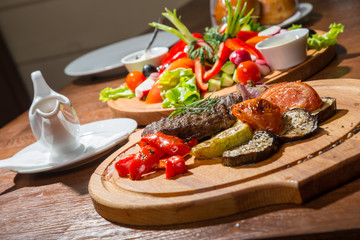 Fototapeta na wymiar Steak with grilled vegetables, on a wooden tray