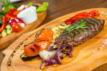 Steak with grilled vegetables, on a wooden tray