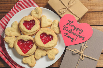Homemade cookies in heart-shaped gifts and red paper hearts, greetings on Valentine's day, top view