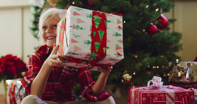 Happy young boy opening christmas presents