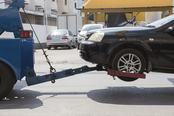 Black ar crash damage delivers to garage by blue truck.