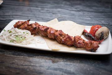 grilled meat on wooden plate marble table