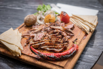 grilled meat on wooden plate marble table