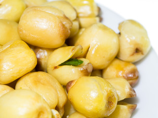 Lotus seeds roasted on white background.