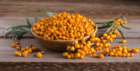 Sea buckthorn in the bowls on wooden table