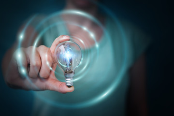 Businesswoman holding a lighbulb with connections in her hand