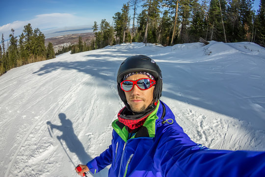 Man skier taking selfie photo with smart cell phone camera