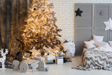 New Year decorated modern interior bedroom with Christmas tree and stars. Scandinavian design room