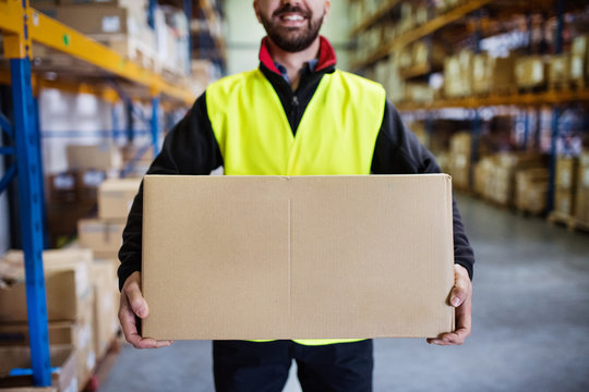 Male warehouse worker with a large box.