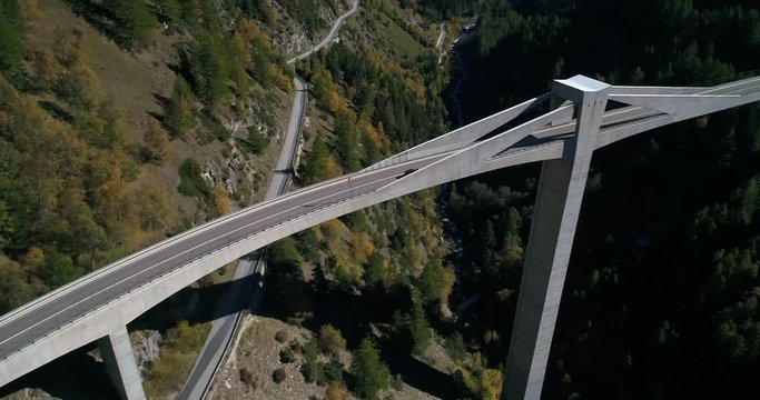 Car on a bridge, Cinema 4k aerial pan view following a car driving over a huge bridge, between mountains, on a sunny fall day, on simplon pass, in wallis, of the alps in Switzerland
