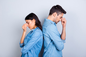 Two entrepreneurs overworked holding their fingers on nose between eyes, relationship of young...